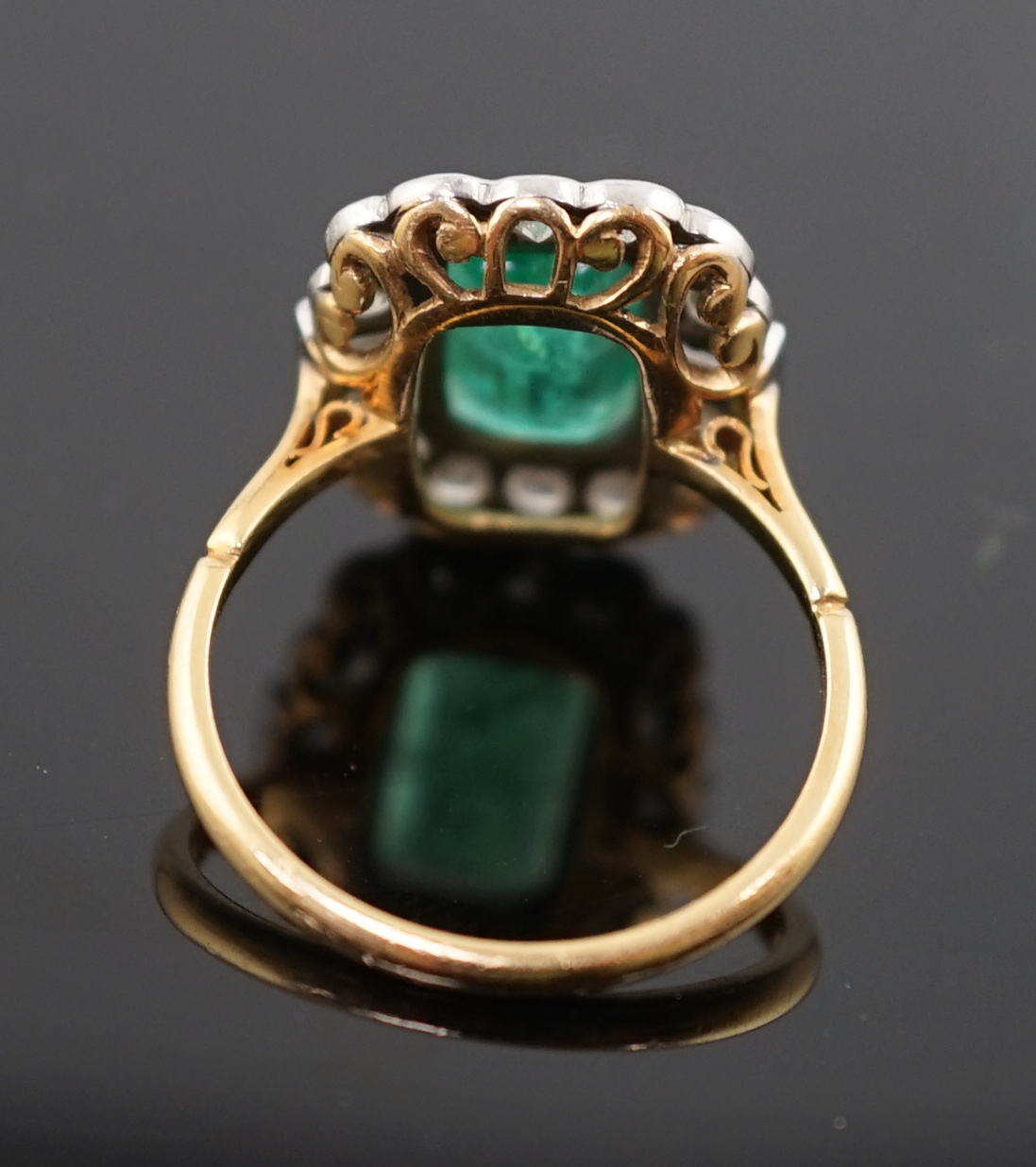 An Art Deco style yellow metal, emerald and diamond set oval cluster ring